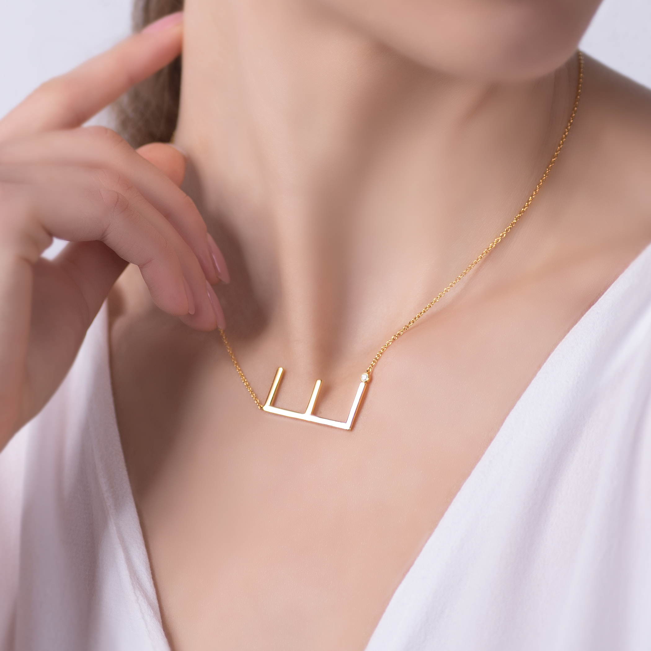 Naszyjnik celebrytka litera E Savicki: srebrny pozłacany, biały szafir