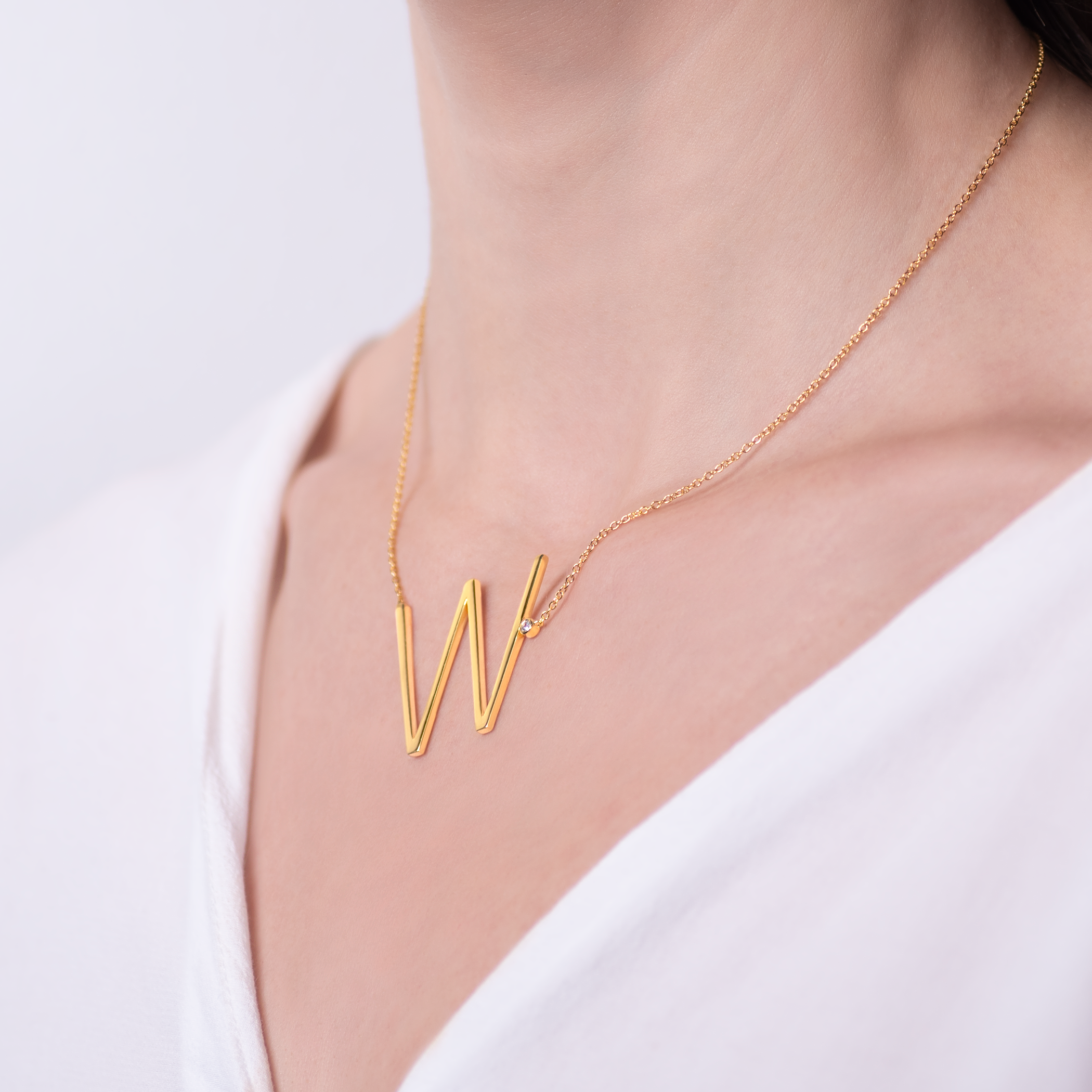 Naszyjnik celebrytka litera W Savicki: srebrny pozłacany, biały szafir